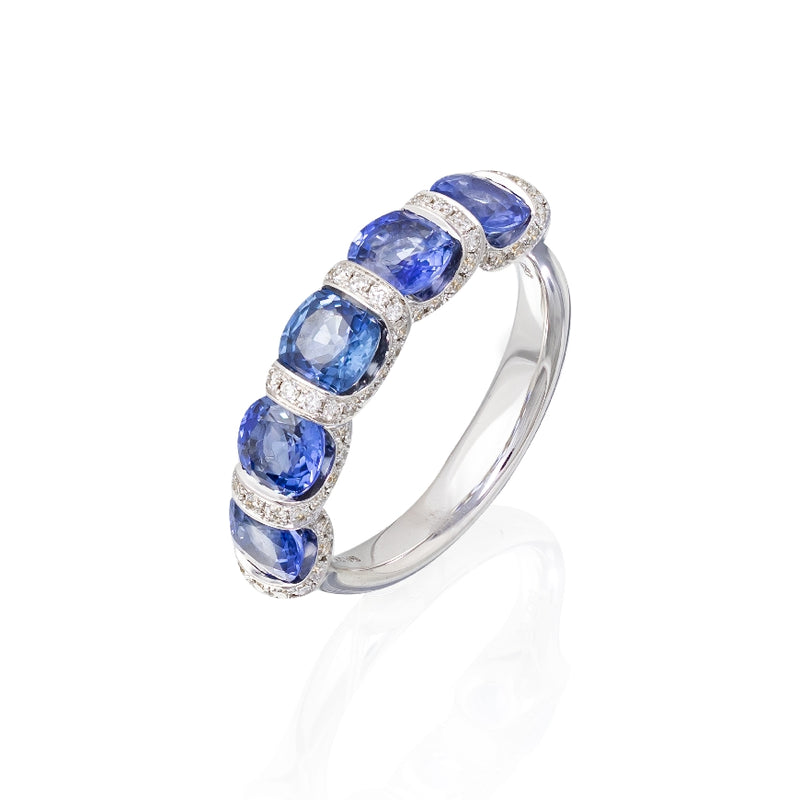 18kt white gold cushion shaped blue sapphie ring with 'u' style setting, pave diamonds. Sapphires have a combined total weight of 3.05cttw and diamonds have a combined total weight of 0.38cttw. G-H Color, SI Clarity.