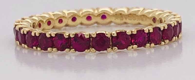 18kt yellow gold ruby eternity ring- shared prong setting. size 6. rubies weigh 1.30cttw