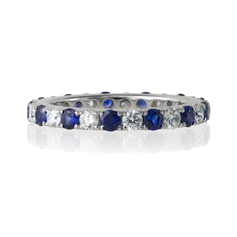 18kt white gold round diamond and round blue sapphire eternity band. Ring consists of 13 blue sapphires 0.86ctw and 13 round diamonds 0.61ctw. Diamonds are G-H Color, SI Clarity.