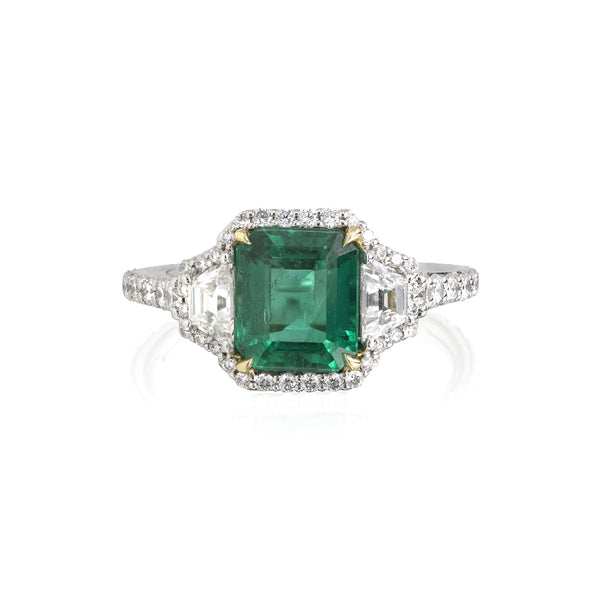 Emerald and diamond ring featuring a 1.61ct Colombian Emerald center stone with .38ct of Trapezoids (1 on either side) that are G color, VS clarity. There is .65ct of diamond pave throughout the ring. Made in 18k yellow gold and platinum. Size 6.5.